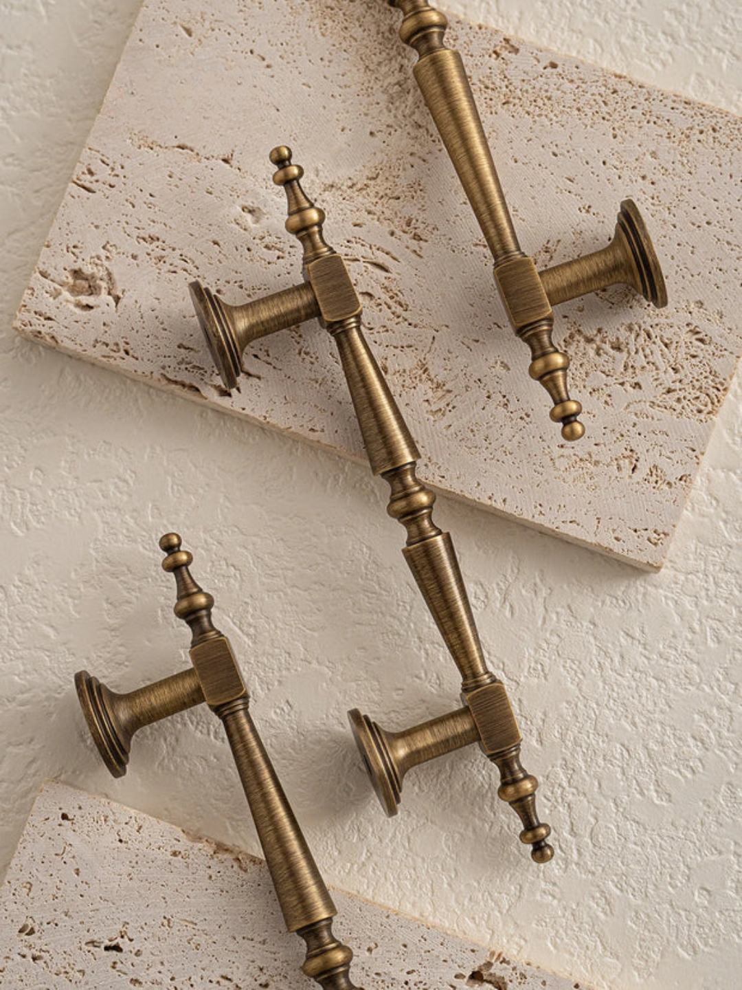 Set of ornate bronze door handles on a green fabric background