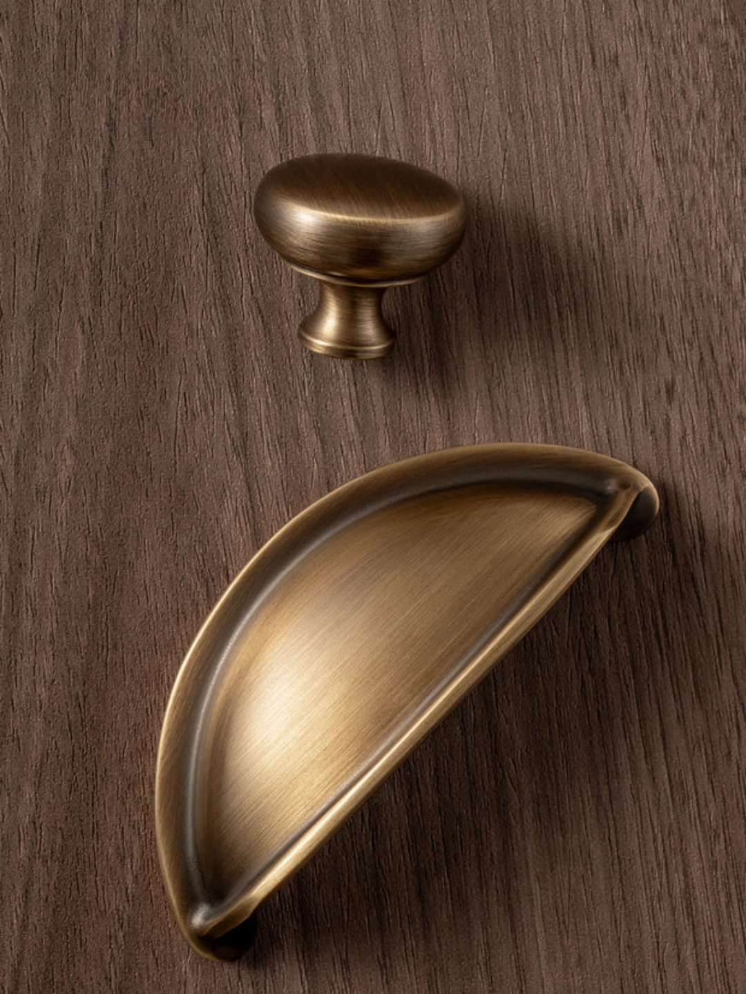 Bronze cabinet knob and pull on a wooden surface