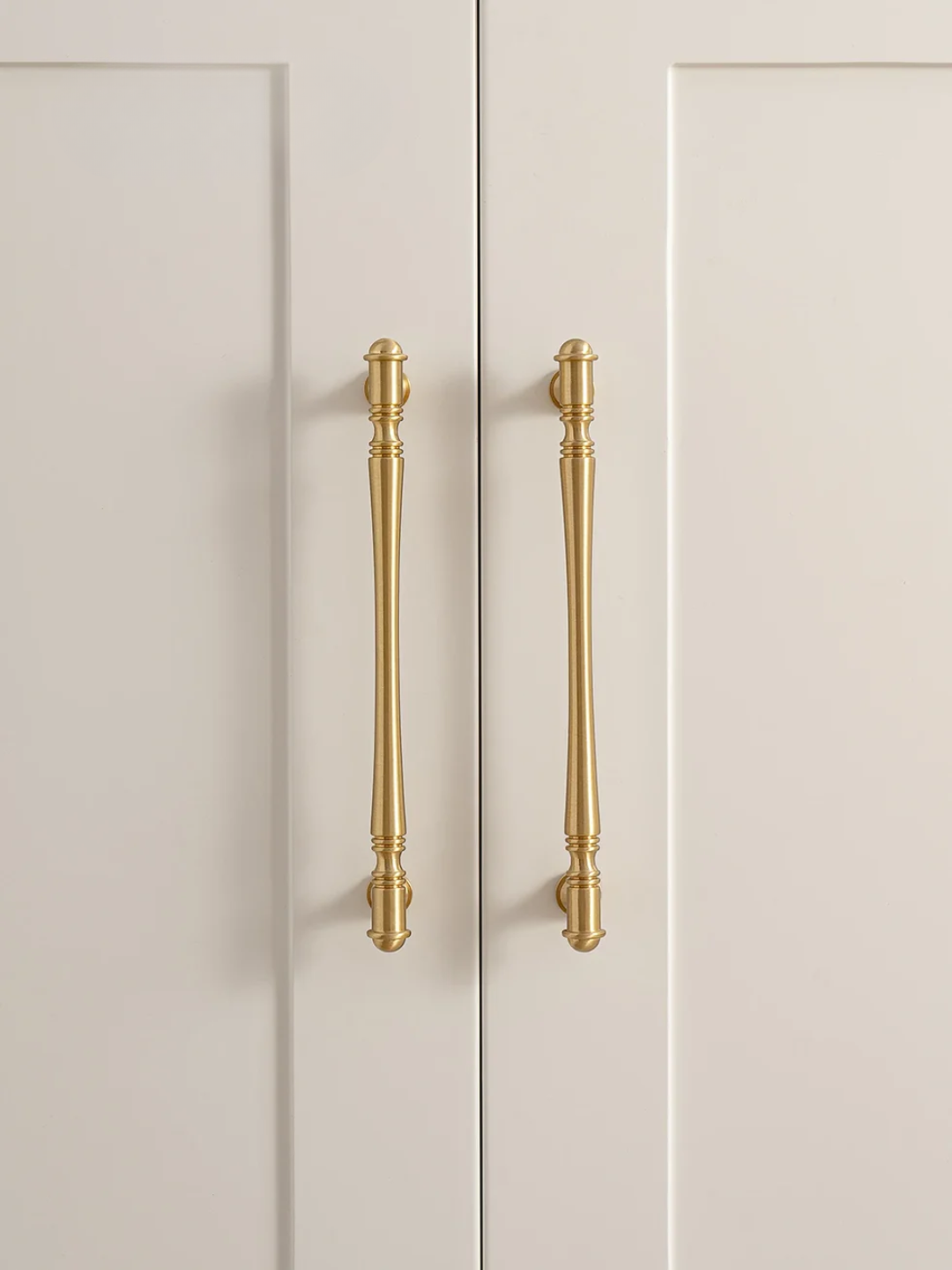 Beige cabinet doors with gold handles on a neutral background