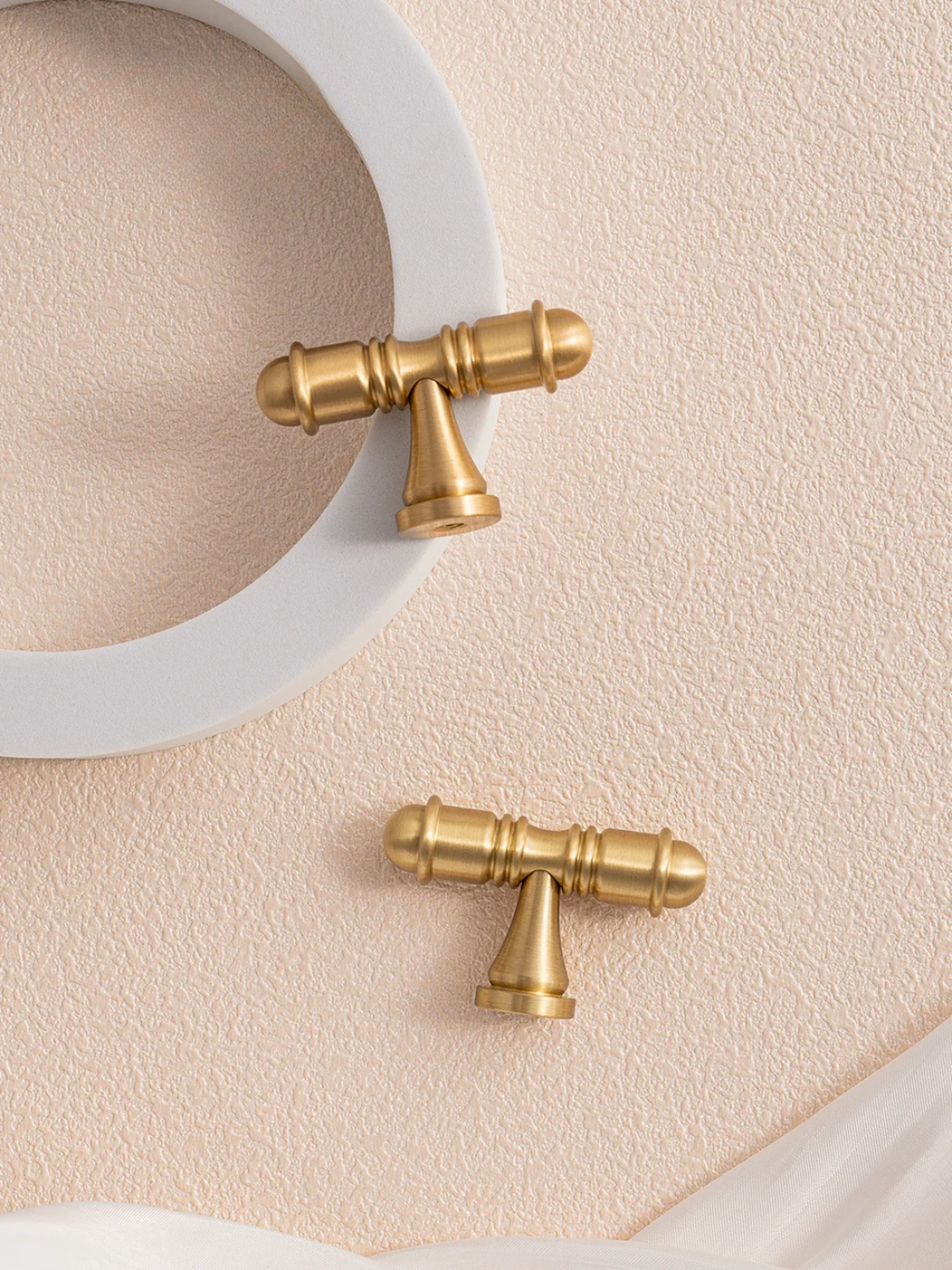 Gold faucet handles on a beige background