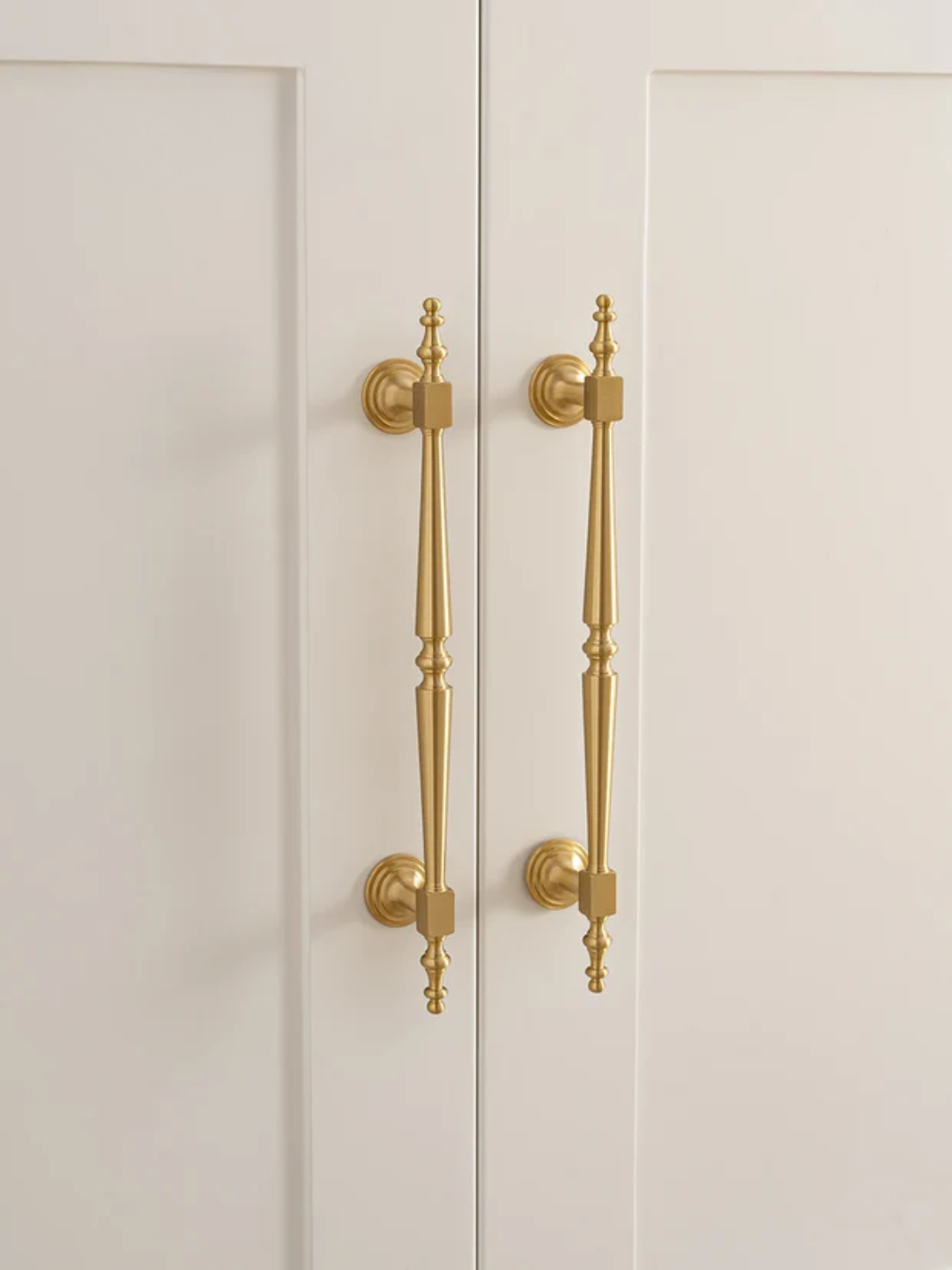 Close-up of a cabinet with gold handles on a white background