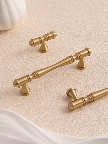 Gold cabinet handles on a beige background with 'Santaya' branding.
