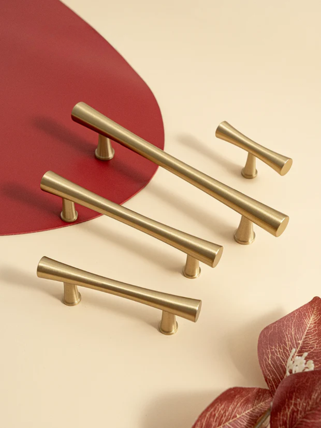 Gold cabinet handles on a beige background.