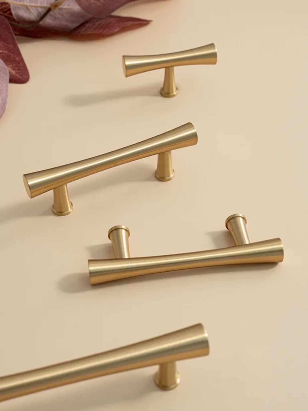 Set of gold cabinet handles on a beige background