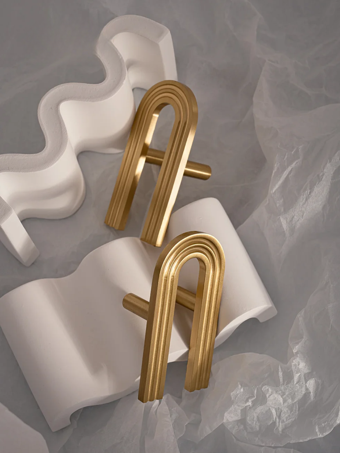Gold earrings on a textured gray background