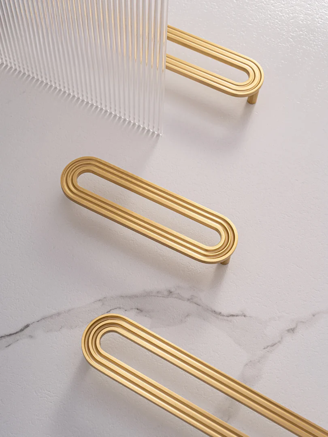 Gold metal handles on a marble surface