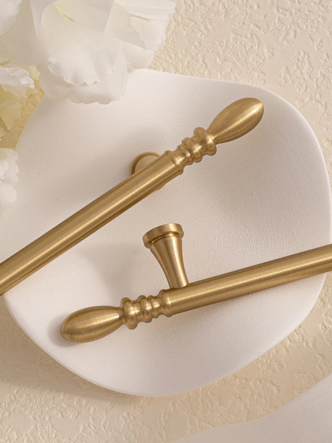 Gold decorative elements on a white plate against a beige background
