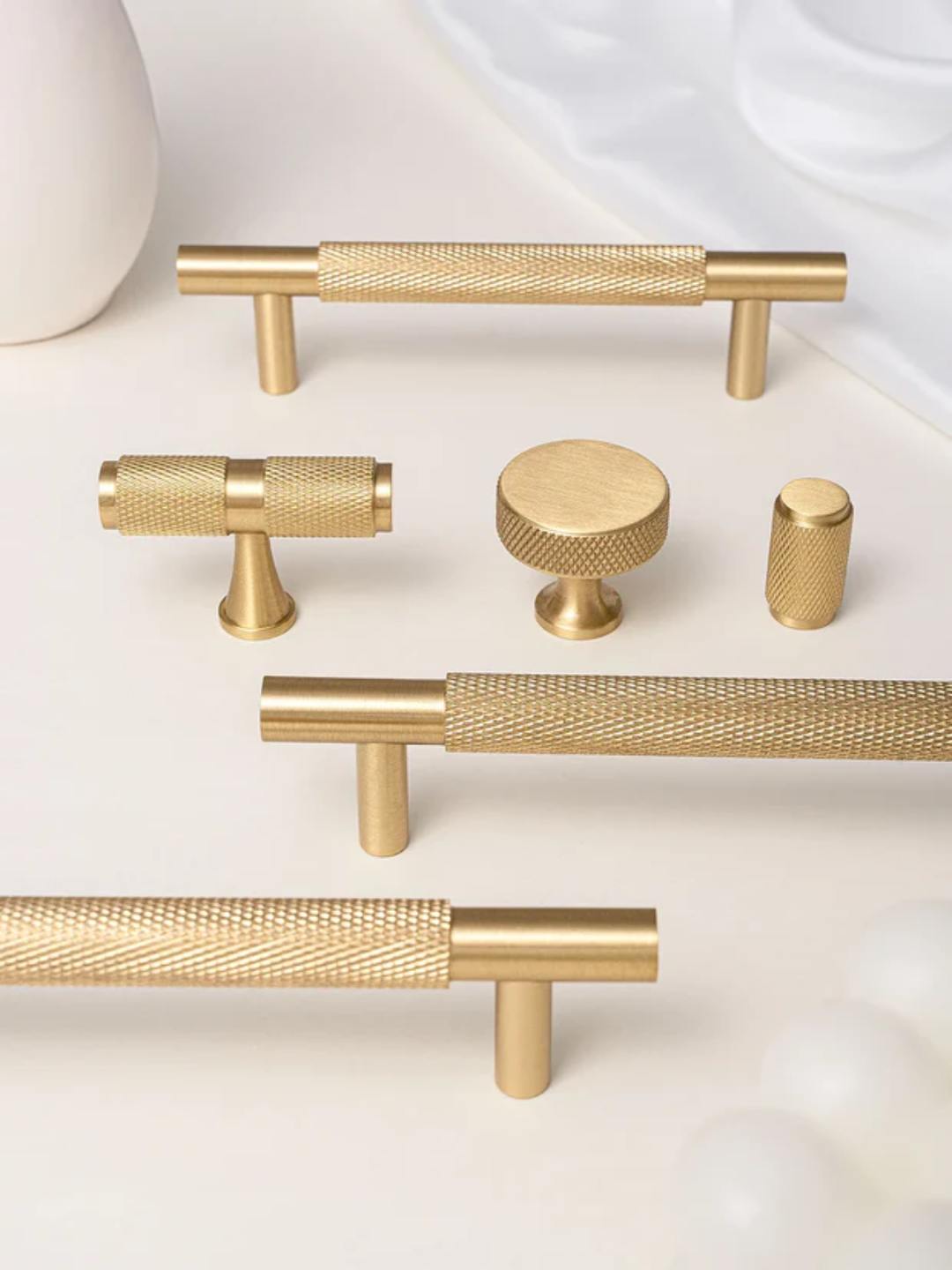 Collection of gold cabinet handles on a white background