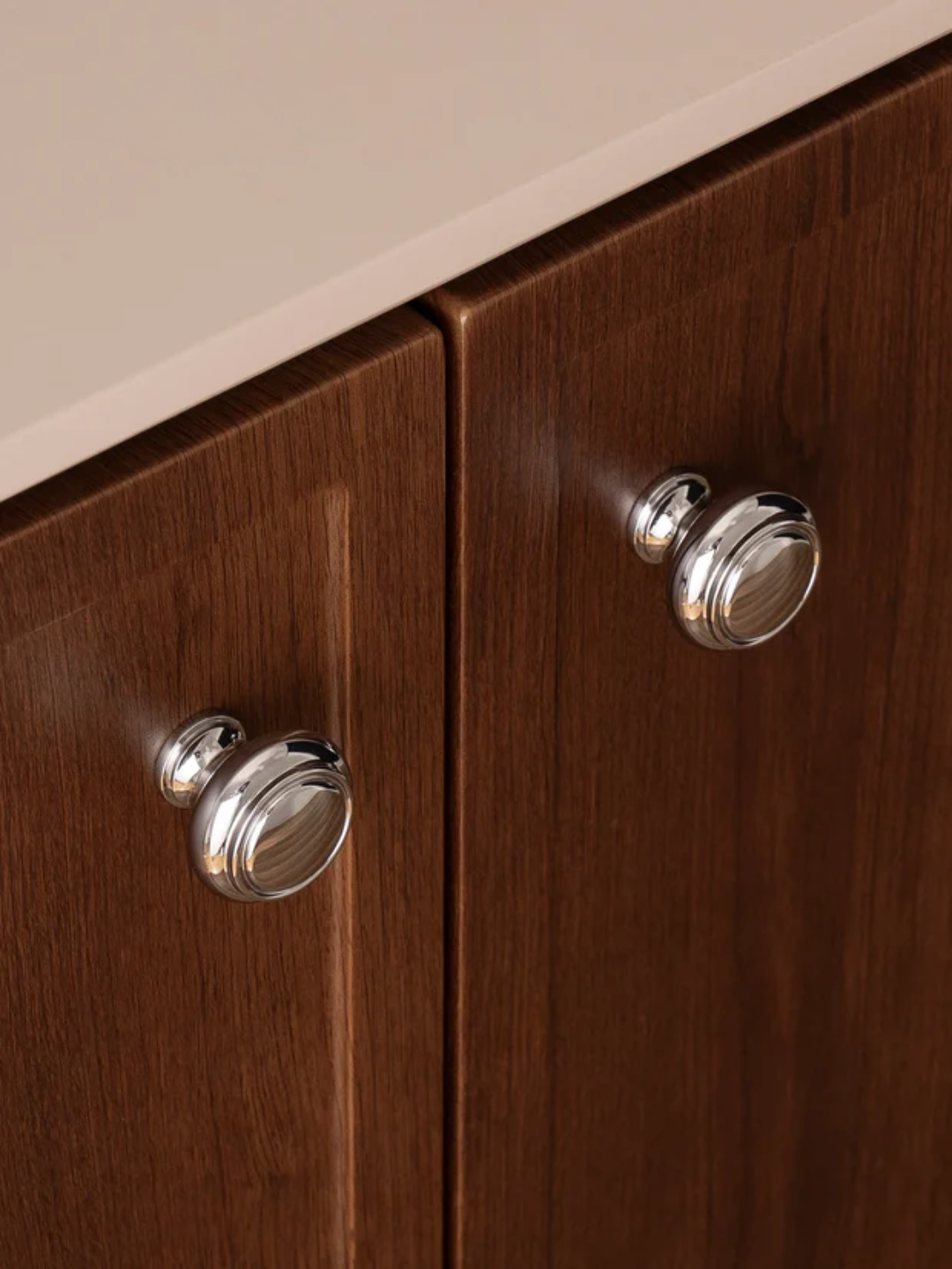 Wooden cabinet with silver knobs on a neutral background
