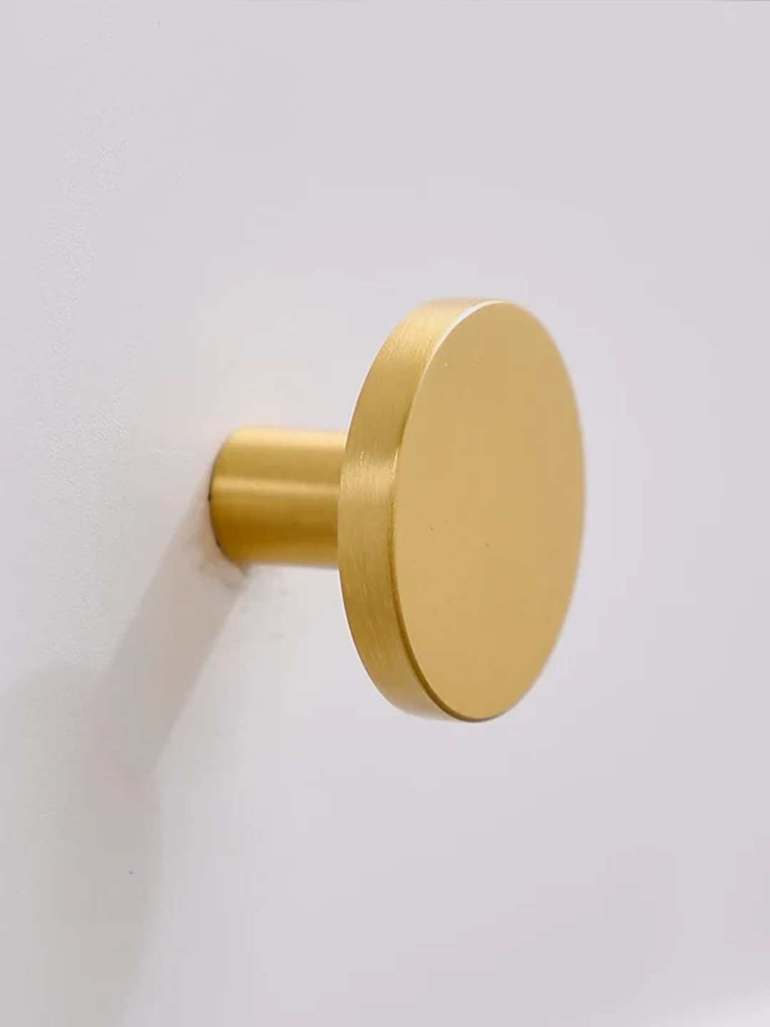 Gold cabinet knob on a white background