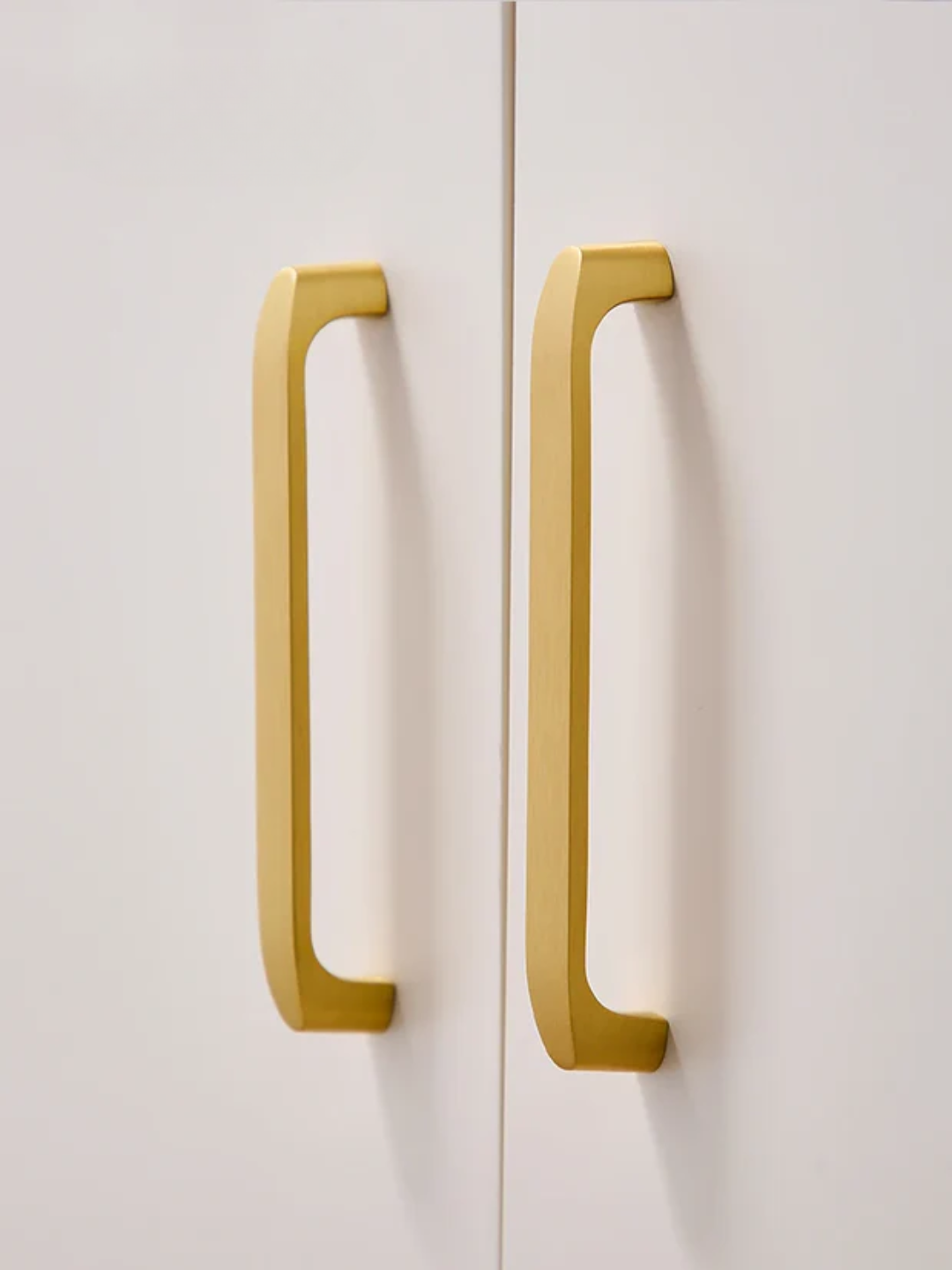 Gold cabinet handles on a white door