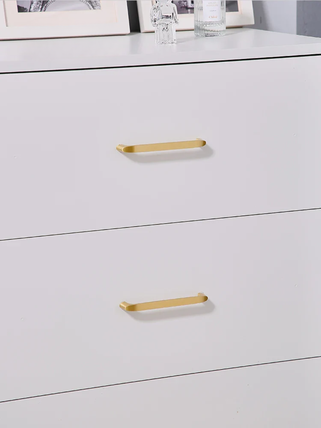White dresser with gold handles on a white background