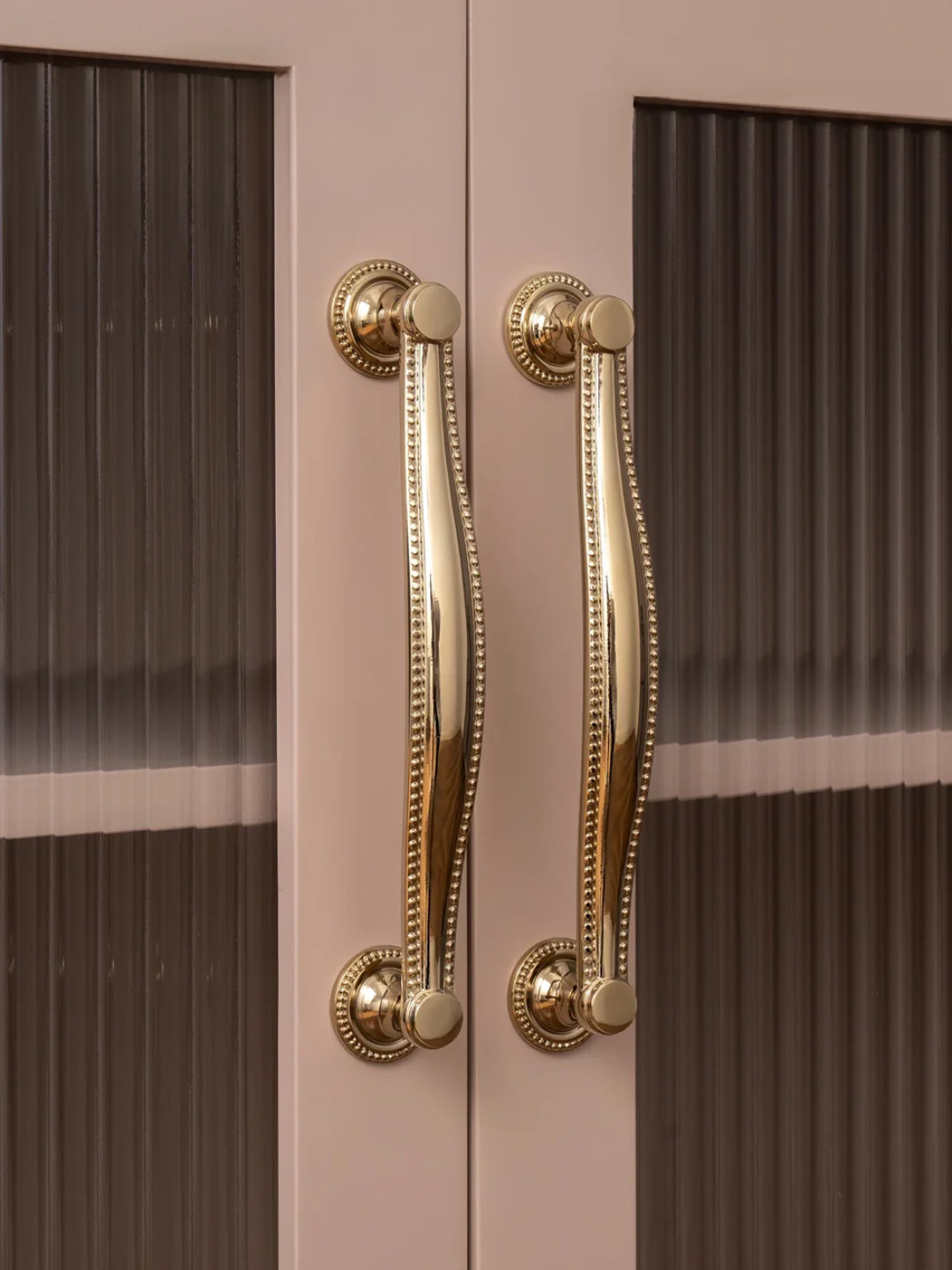 Close-up of a door with gold handles on a brown background