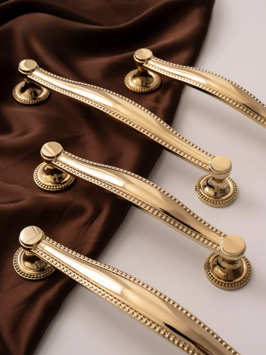 Gold door handles on a brown and white fabric background