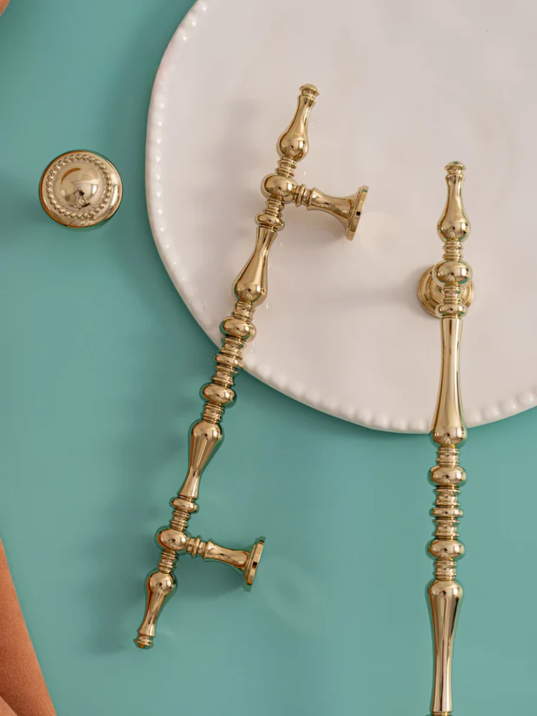 Gold bathroom fixtures on a teal background
