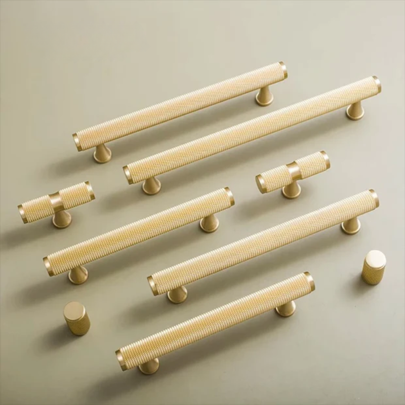 Set of gold cabinet handles on a beige background