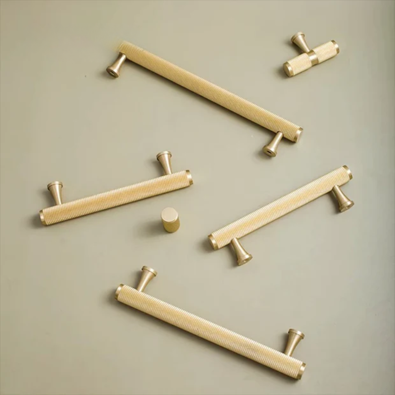 Set of gold cabinet handles on a beige background