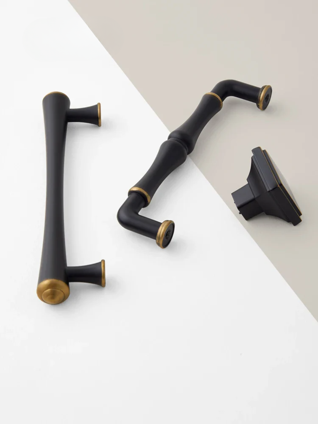 Set of black and gold cabinet handles on a gray surface
