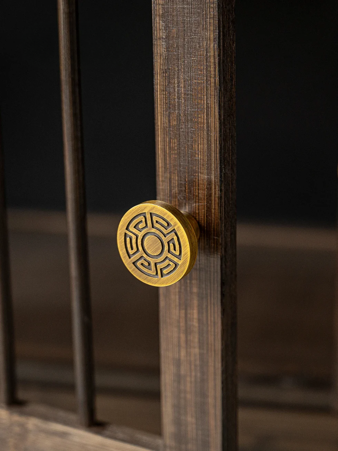 Close-up of a wooden door handle with intricate design on a dark background
