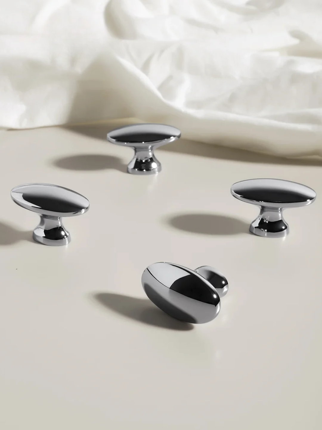 Set of five chrome cabinet knobs on a light background
