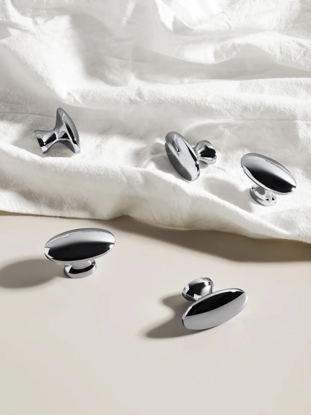 Silver oval-shaped buttons on a white fabric background