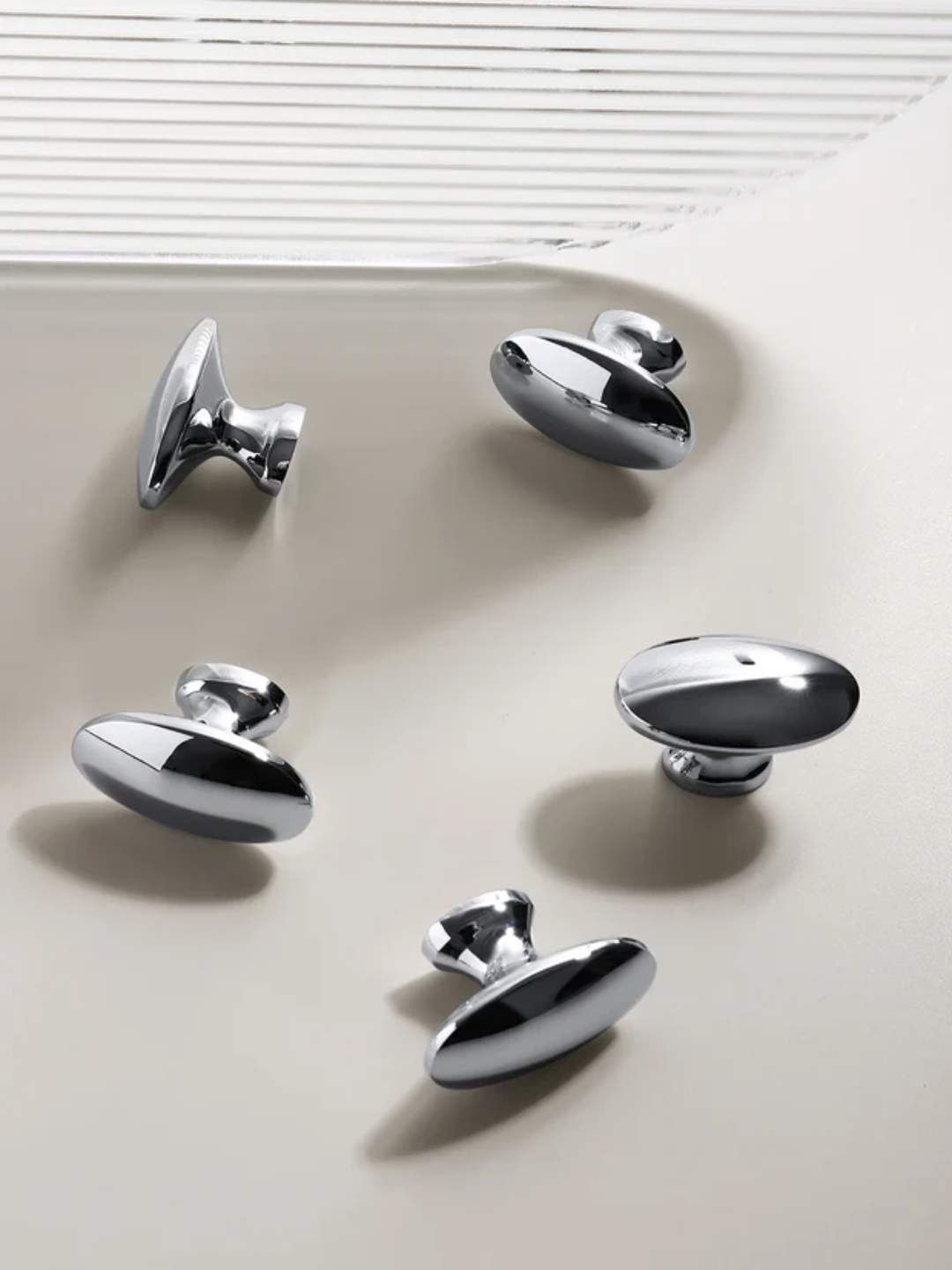 Set of six chrome cabinet knobs on a neutral background