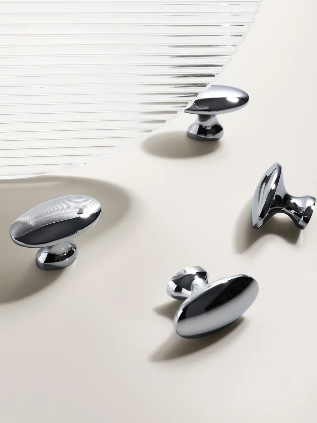 Chrome cabinet knobs on a light surface with a white background