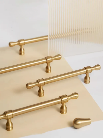Set of gold cabinet handles on a neutral background