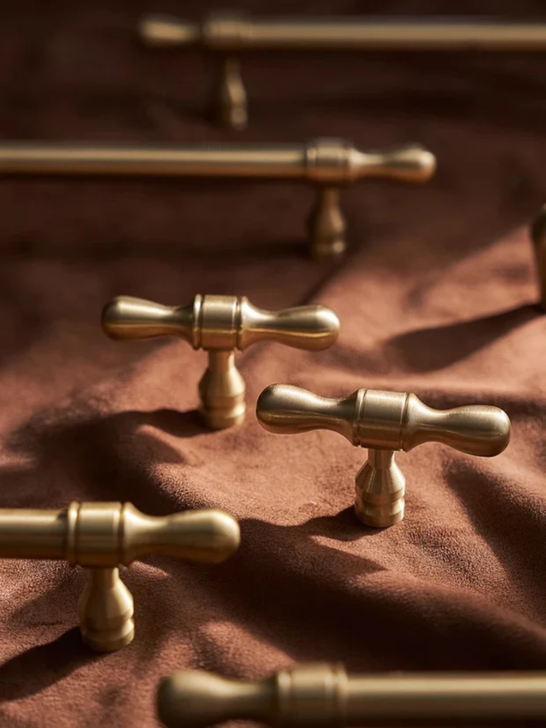 Set of gold cabinet handles on a neutral background