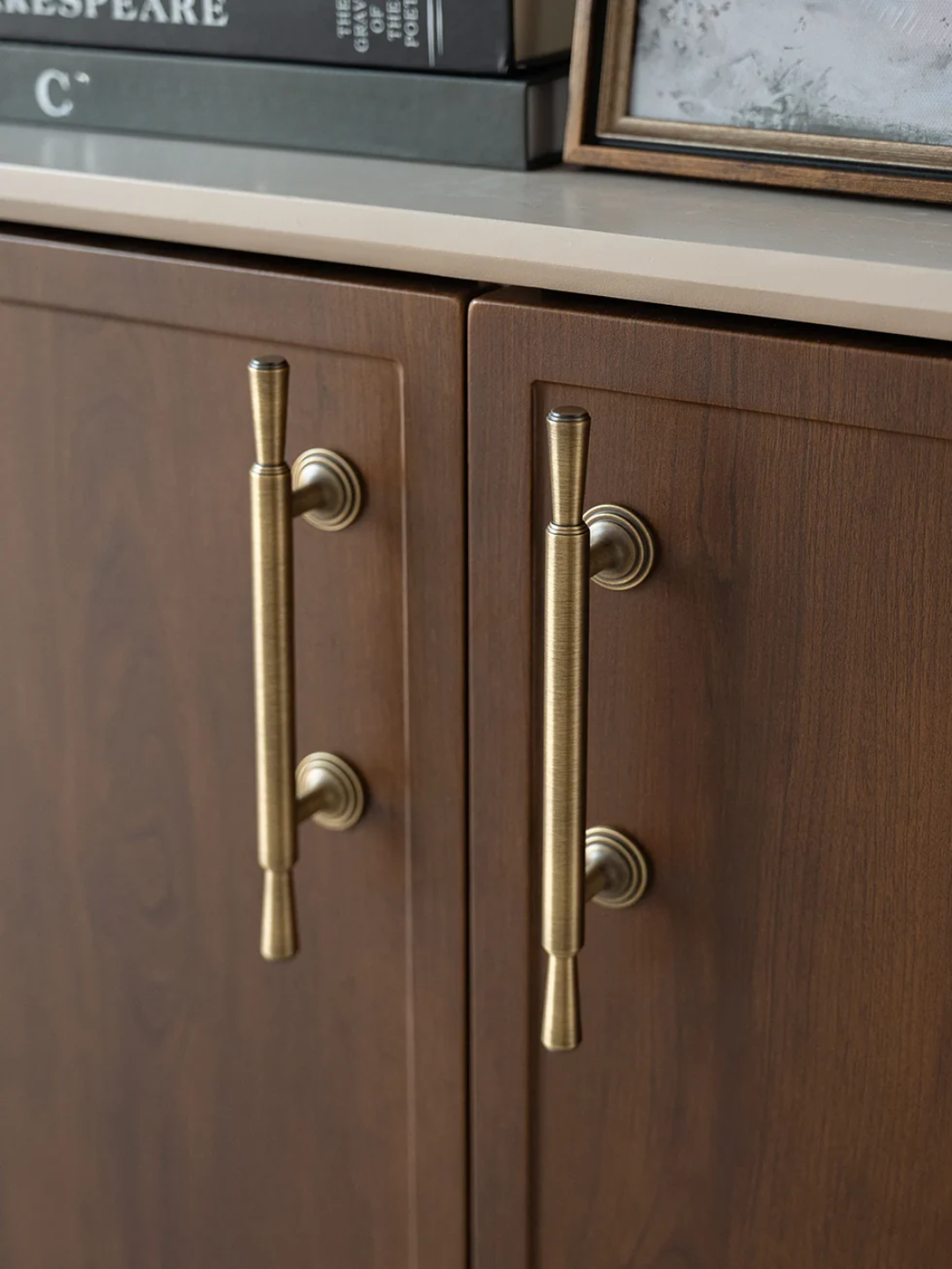 Wooden cabinet with brass handles on a neutral background
