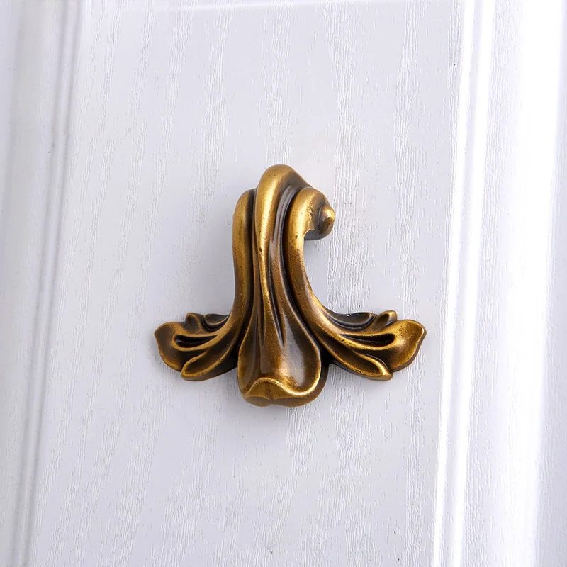 Decorative brass door knocker on a white wooden door