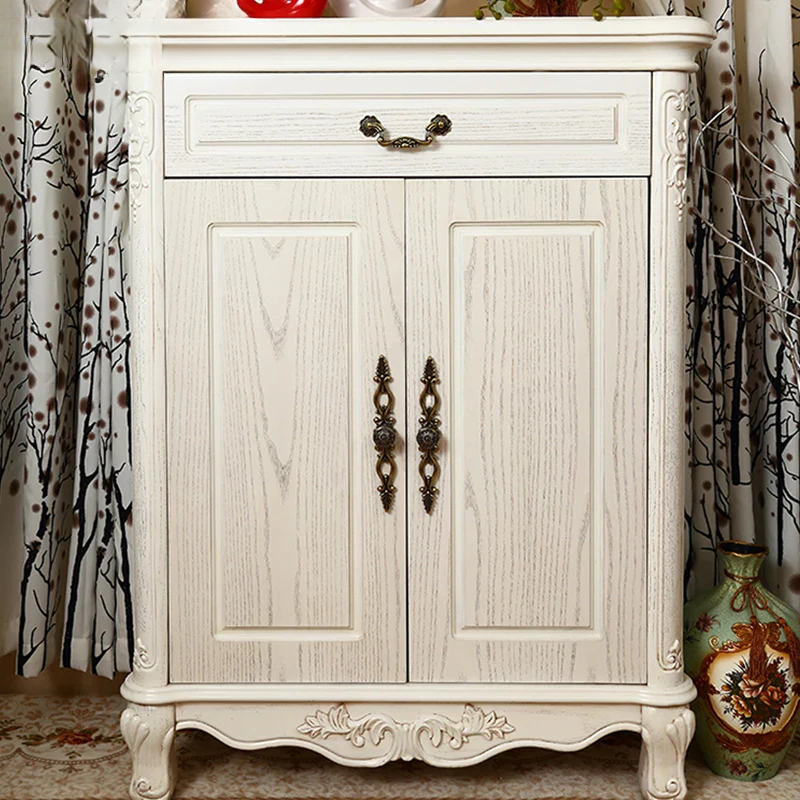 White wooden cabinet with decorative elements in a room setting.