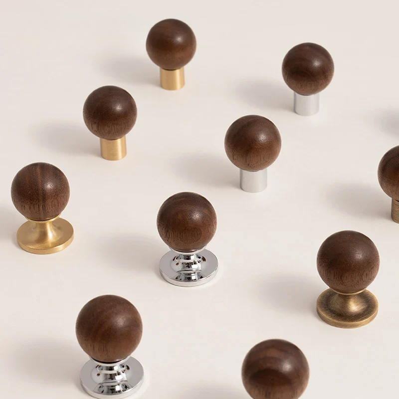 Set of wooden knobs with gold, silver, and bronze bases on a white background
