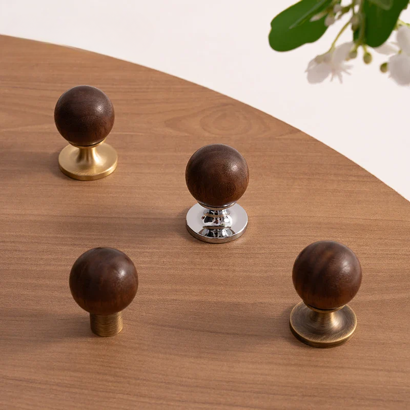 Set of wooden knobs with gold, silver, and bronze bases on a white background