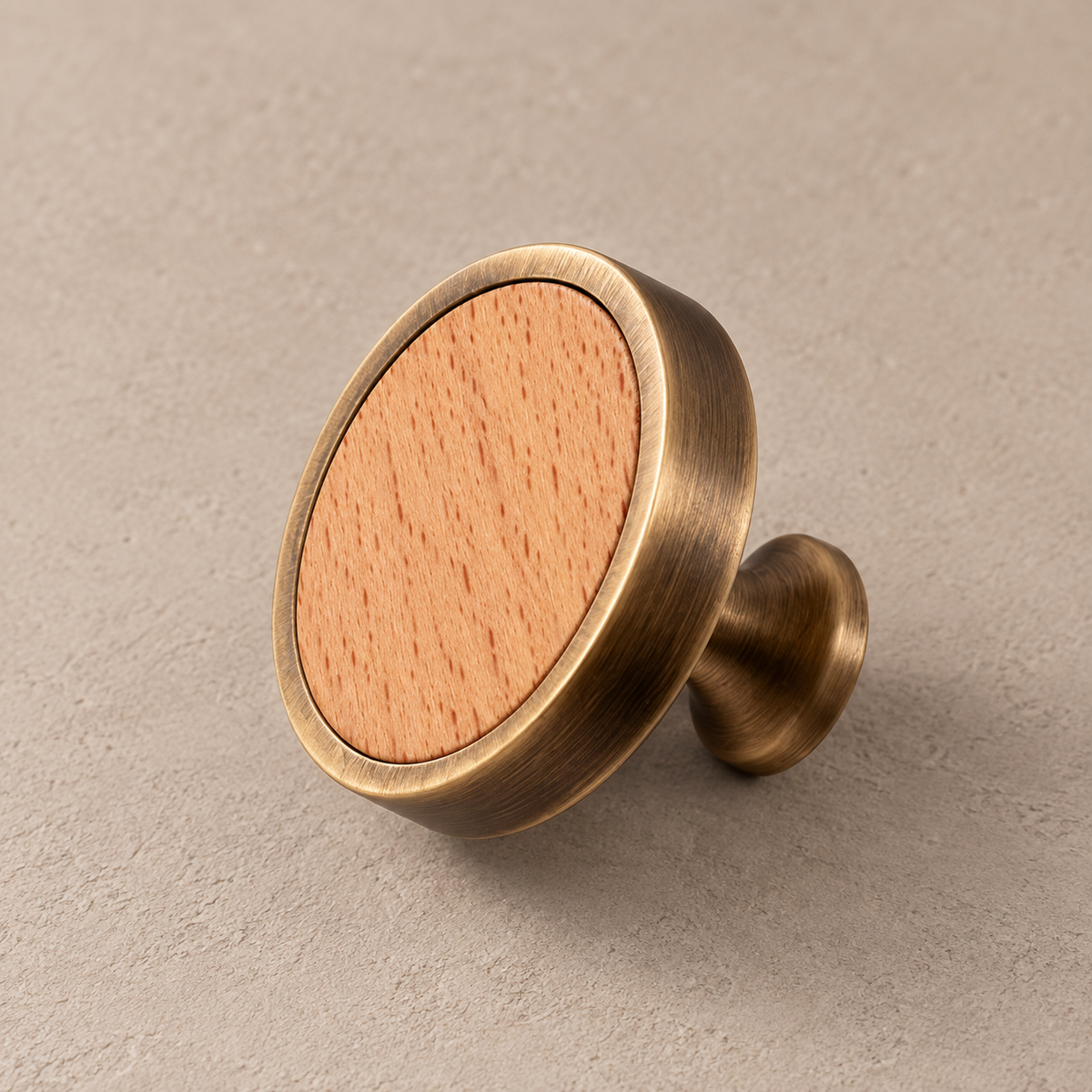 Antique brass cabinet knob with beech inlay on taupe studio background