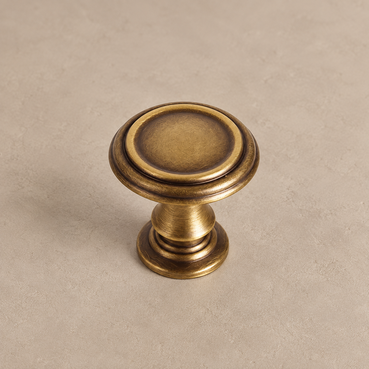 Antique brass round knob with concentric rim and stepped base