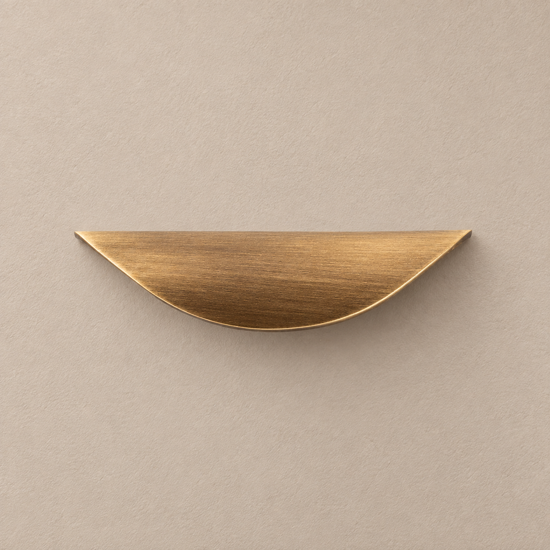 Solid Brass Leaf Cabinet Pull — Antique Brass on a neutral stone studio background