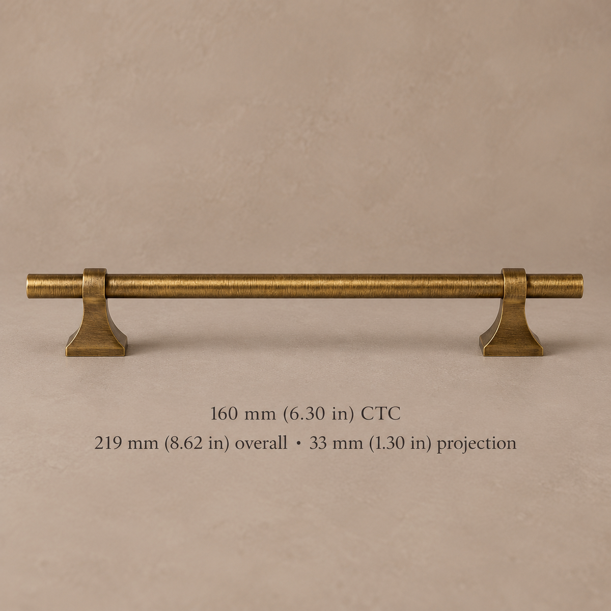 Antique brass cabinet pull with flared square feet, 160 mm center-to-center, millimetre and inch dimensions on taupe background