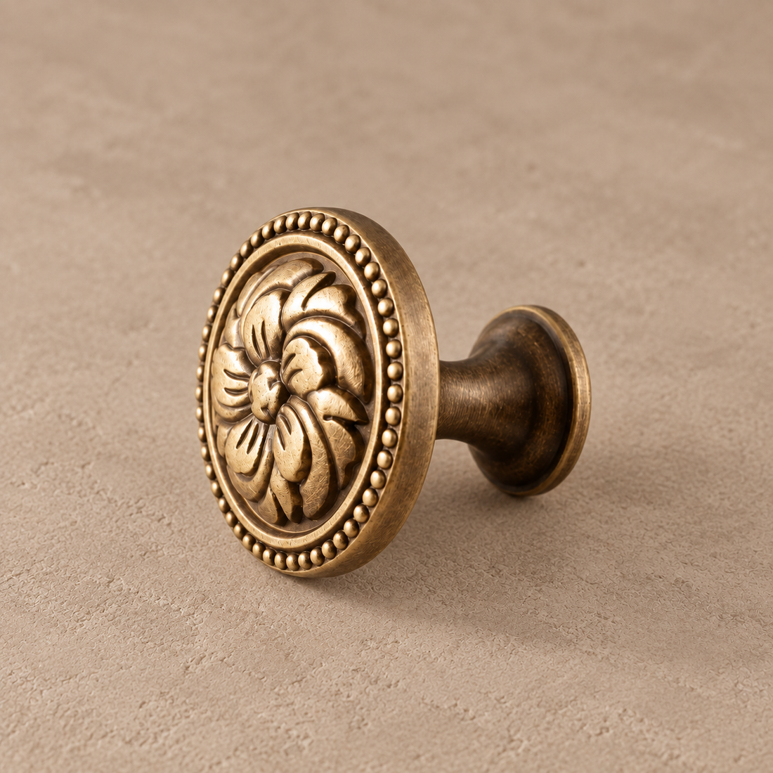 Solid Brass Floral Cabinet Knob — Antique Brass on a neutral stone studio background