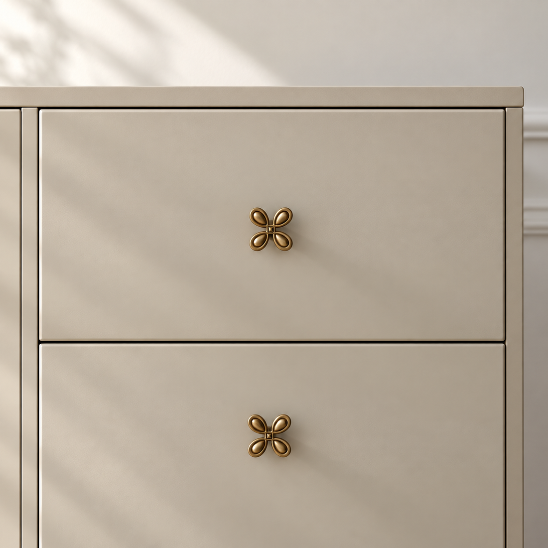 Solid Brass Four-Leaf Cabinet Knob — Antique Brass on a warm ivory background