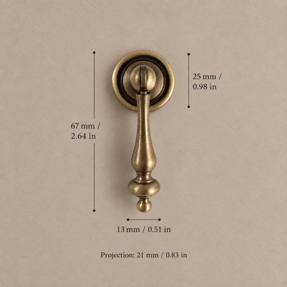 Antique brass pendant cabinet knob, 67 mm overall, with matching millimetre and inch measurements on taupe