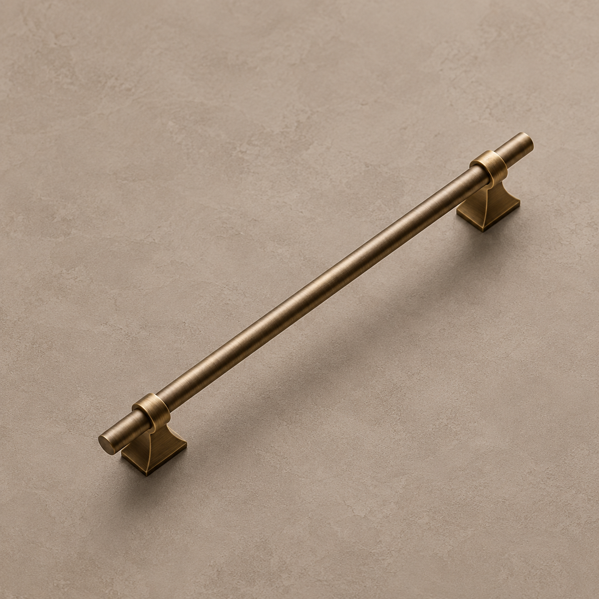Antique brass cabinet pull on a warm taupe studio background