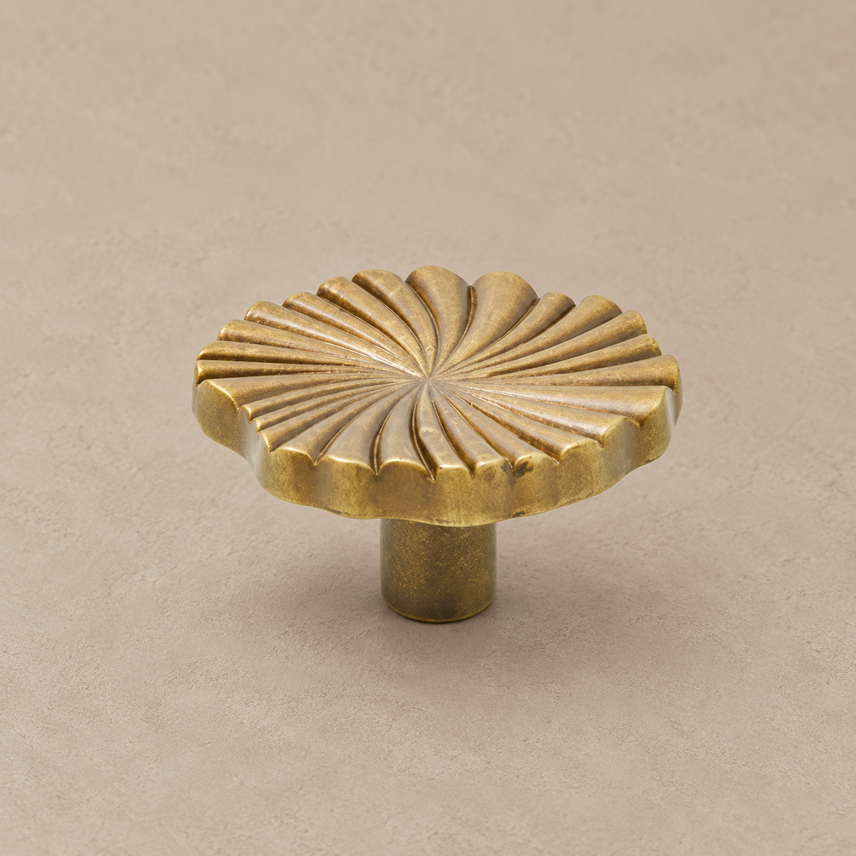 antique brass ruffled knob on warm taupe studio surface