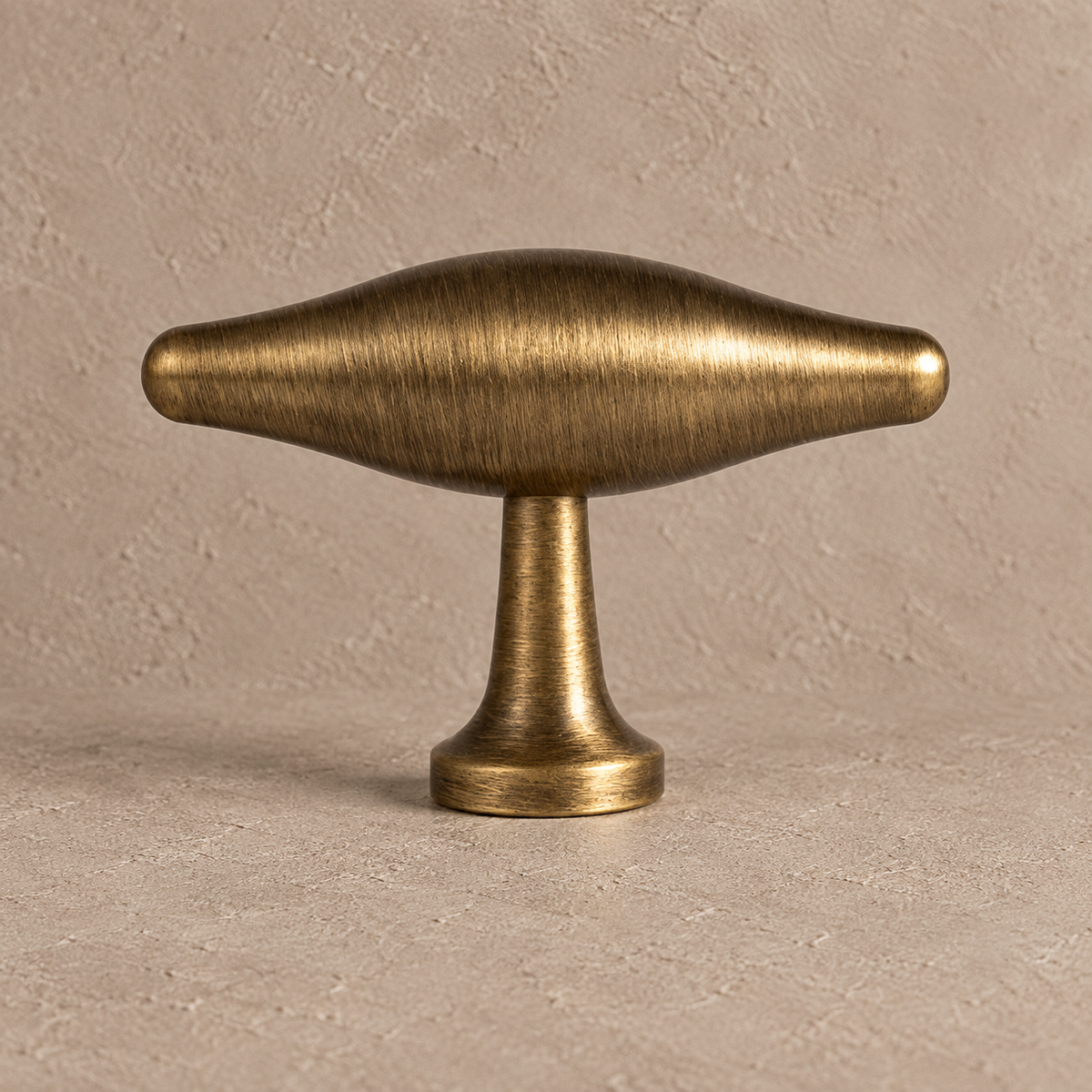 Antique brass squared U-bar cabinet hardware t knob detail on taupe plaster