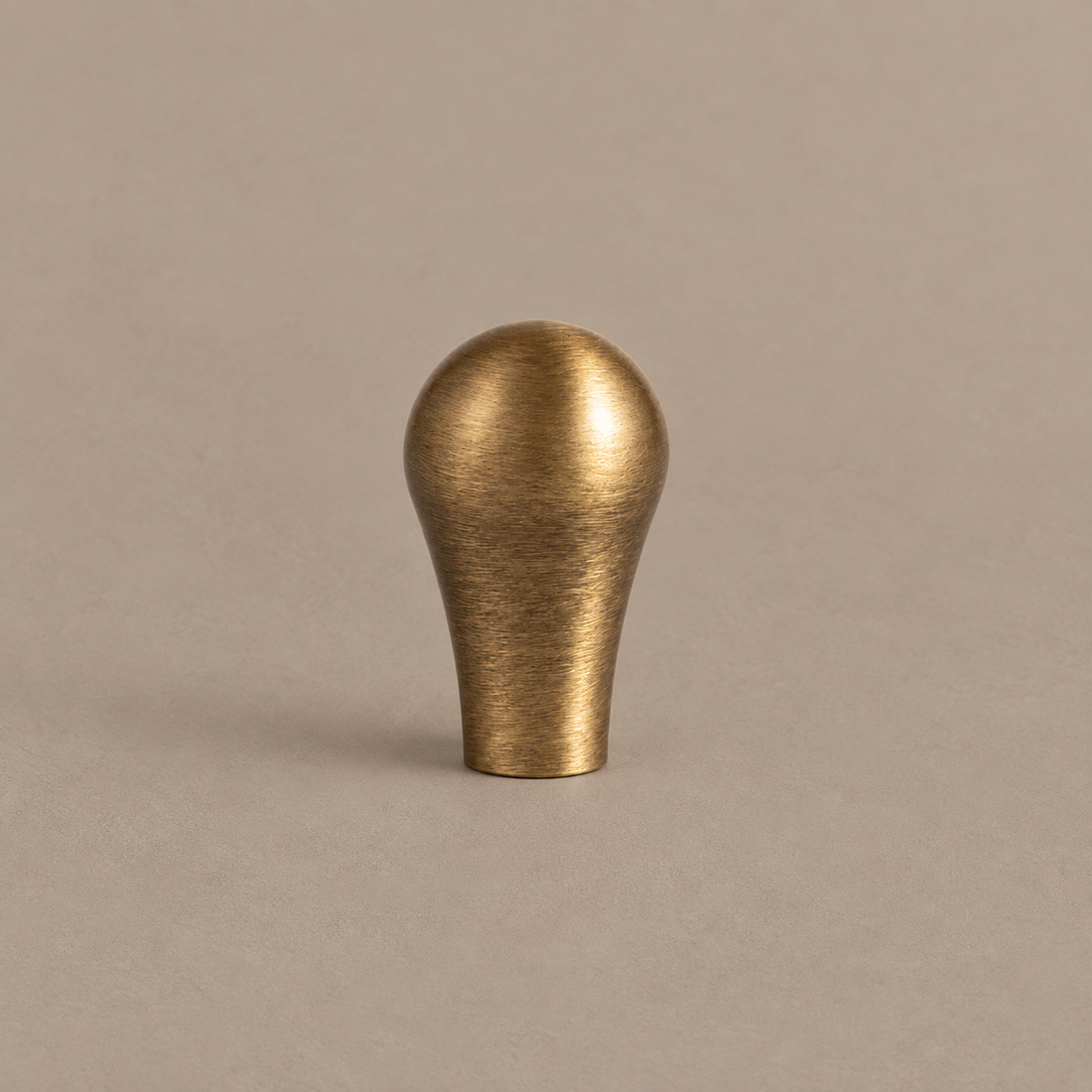 Antique Brass Water-Droplet Cabinet Pulls & Knobs — Luxury Design on warm ivory stone