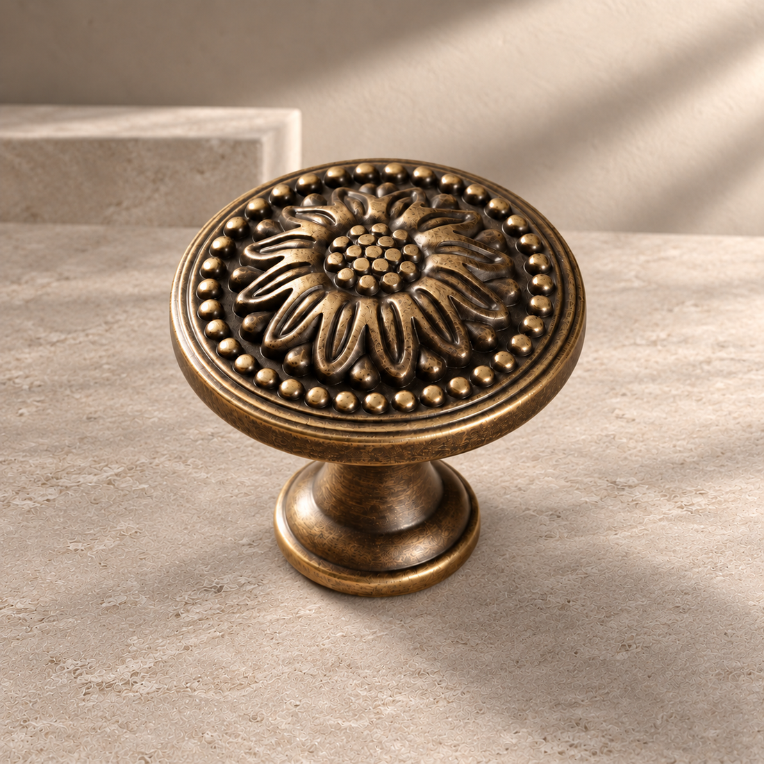 Solid Brass Chrysanthemum Cabinet Knob — Antique Brass on a neutral stone studio background