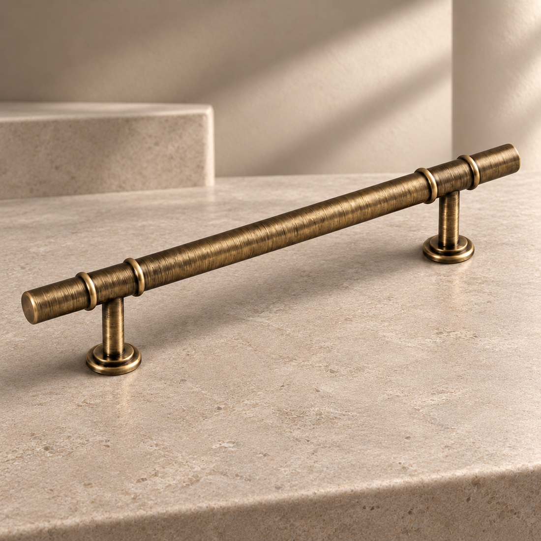Modern Conical Solid Brass Cabinet Pulls & Knobs — Antique Brass on a neutral stone studio background