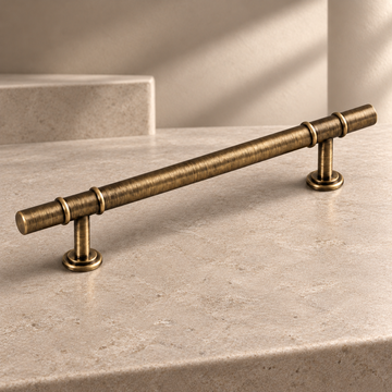 Modern Conical Solid Brass Cabinet Pulls & Knobs — Antique Brass on a neutral stone studio background