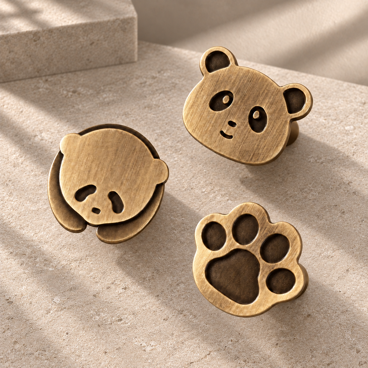 Solid Brass Panda & Paw Cabinet Knobs — Antique Brass on a neutral stone studio background
