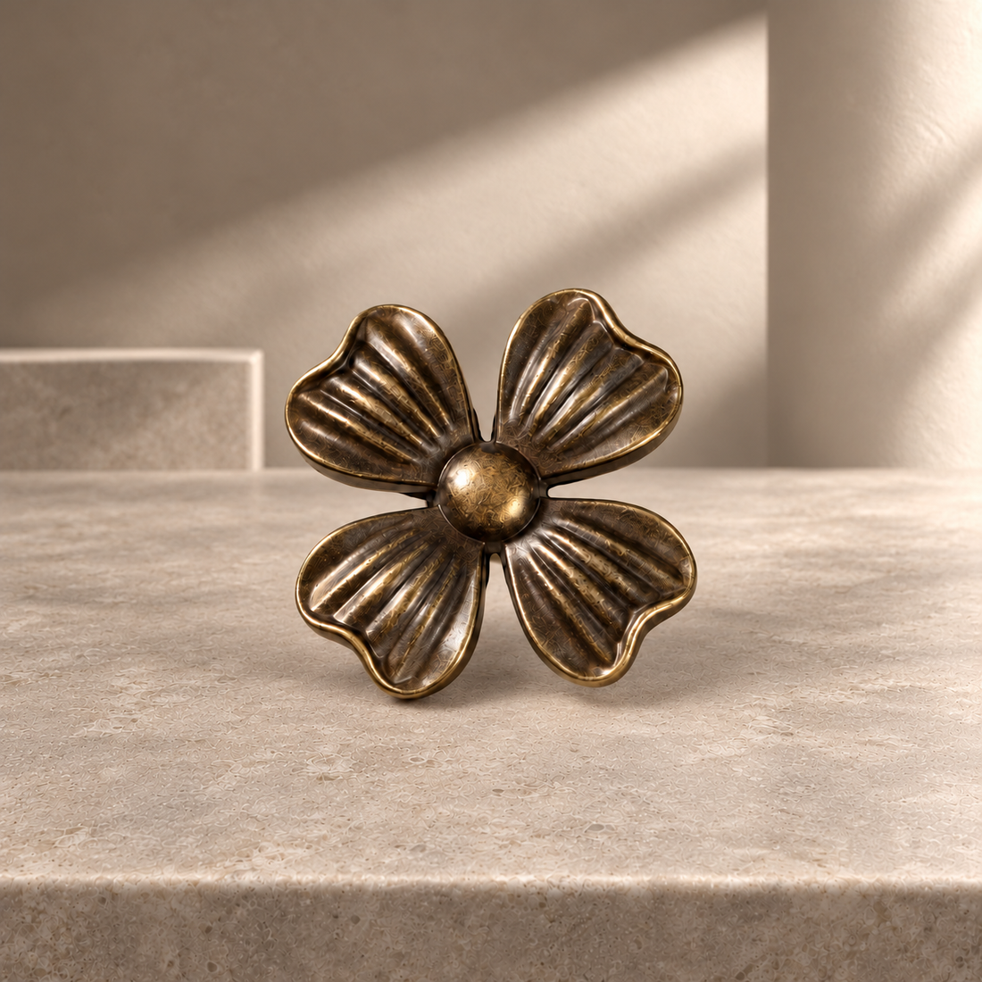 Antique Brass Petal-Design Solid Brass Cabinet Knob on a neutral stone studio background